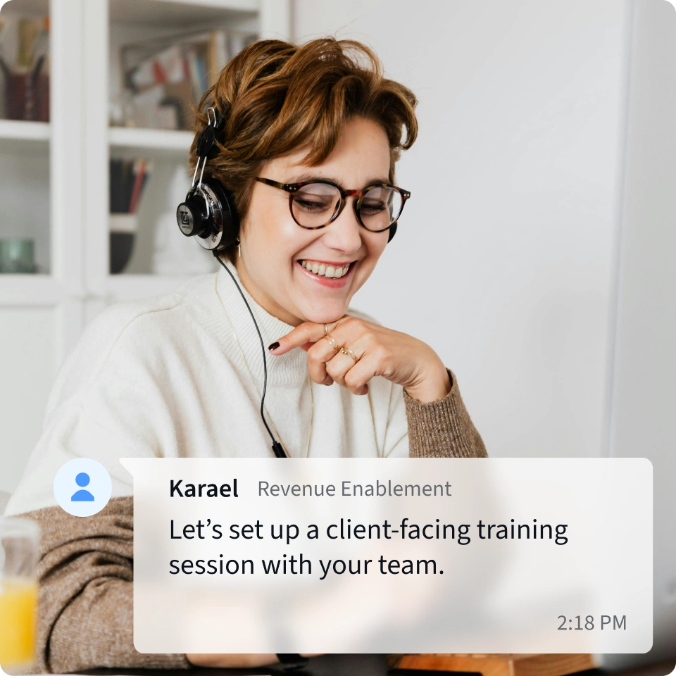 A revenue enablement professional with a headset is coordinating a meeting with a partner. 