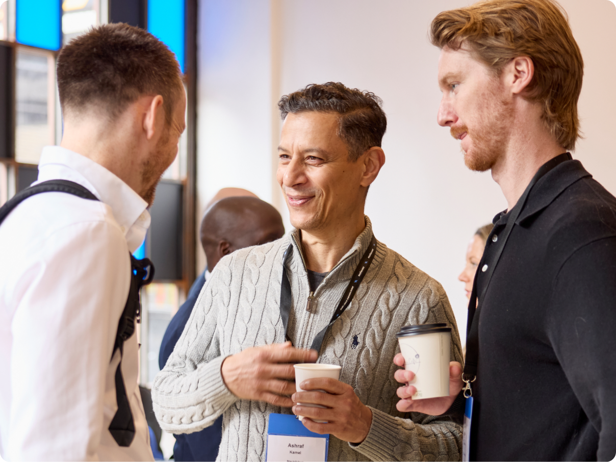 Conference attendees chatting and networking with coffee.