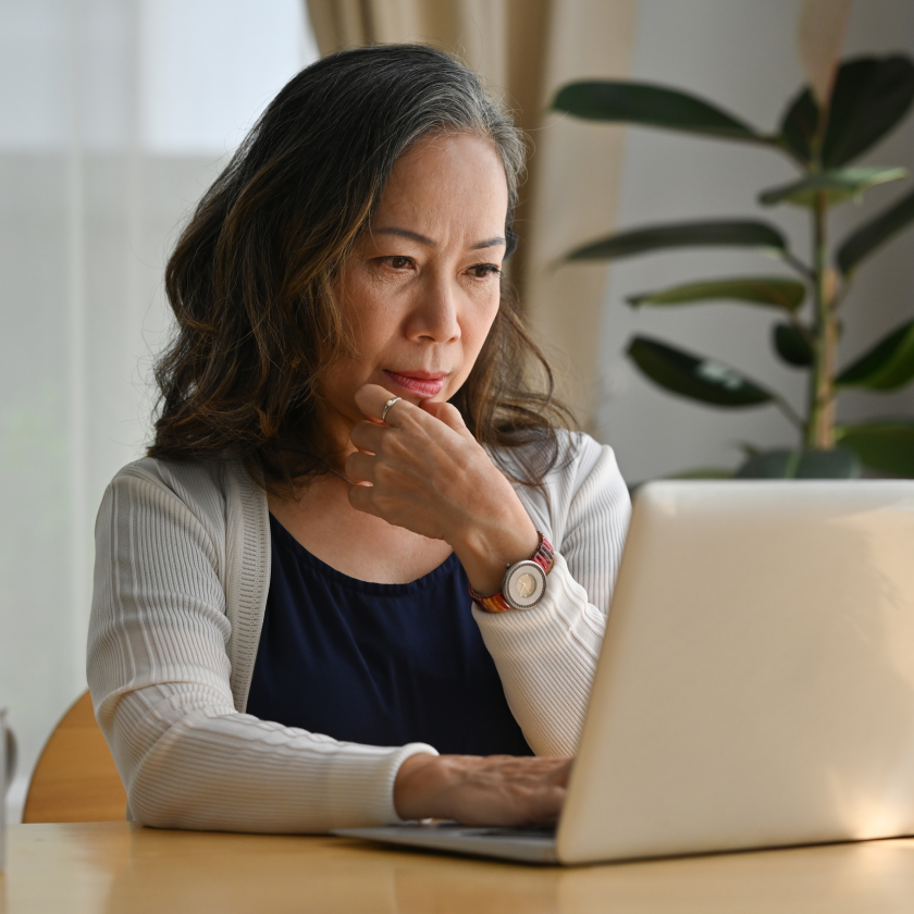 Person using a laptop at a table, representing travel planning and online research.
