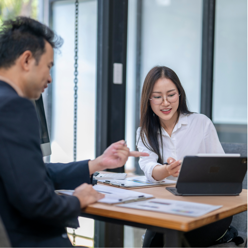 Person sitting at a table using a laptop in an indoor setting.