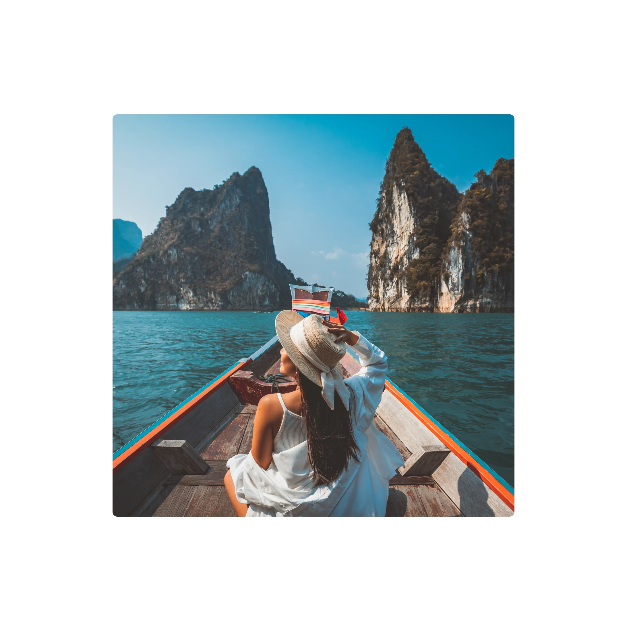 Traveller sitting on a boat looking out at coastal cliffs, representing leisure travel and destination experiences.