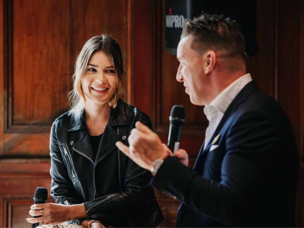Two speakers on a panel leading a discussion at an event.