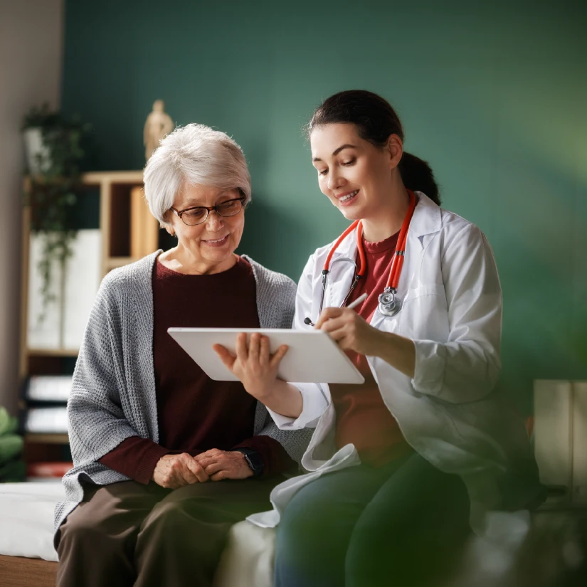 Doctor reviewing a tablet with a patient in a medical office.