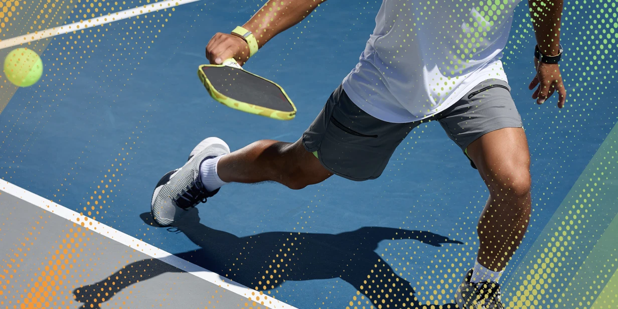A person plays pickleball on a court.