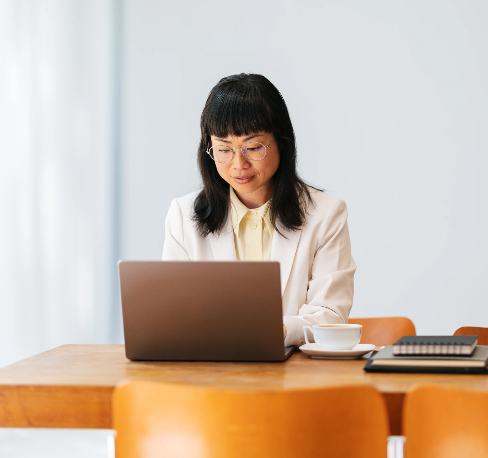 Person working on a laptop in a bright office setting.