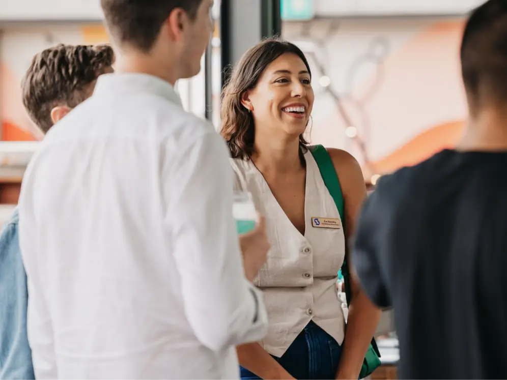 A woman chats with peers at a marketing networking event.