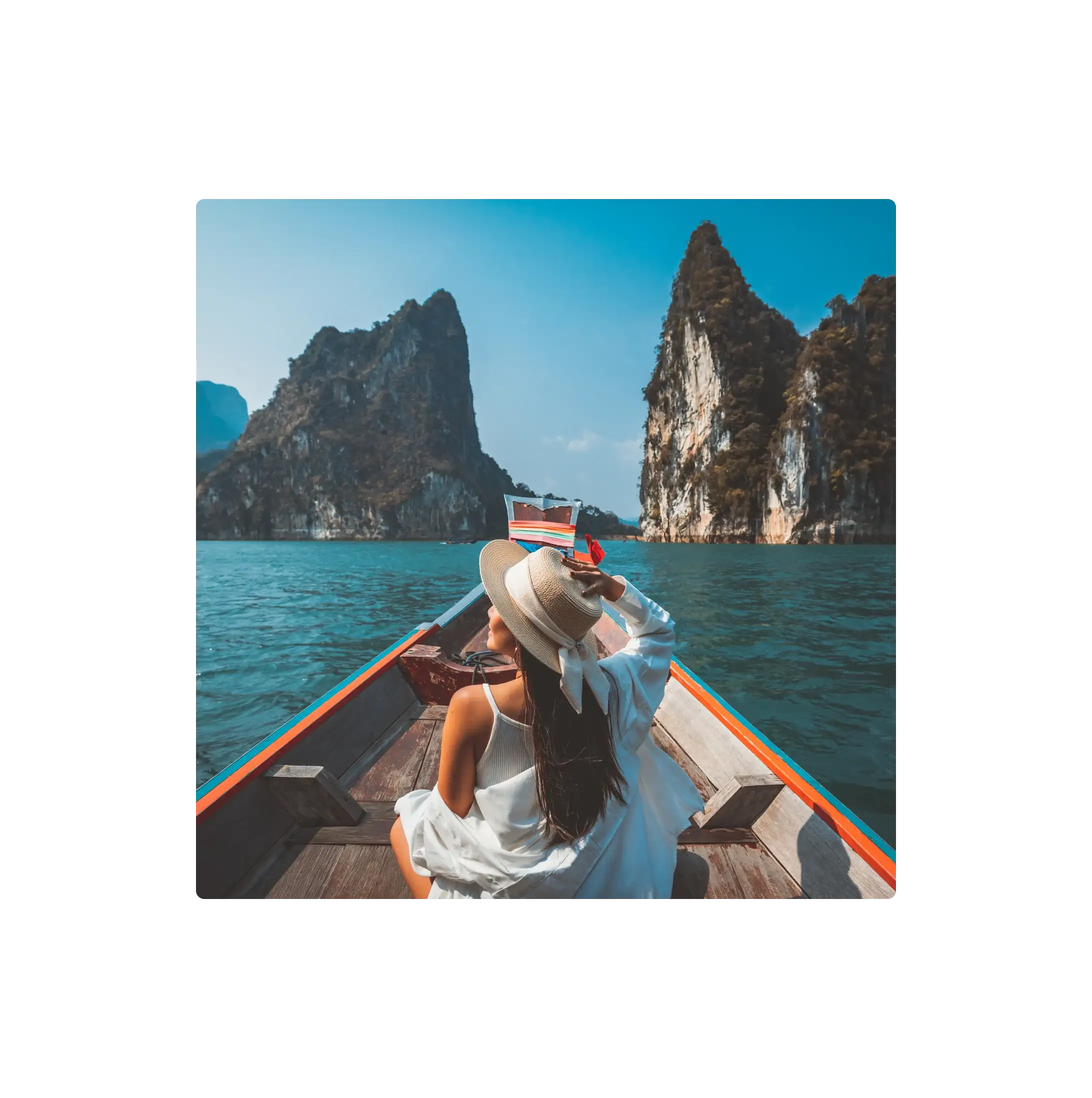 Traveller sitting on a boat looking out at coastal cliffs, representing leisure travel and destination experiences.